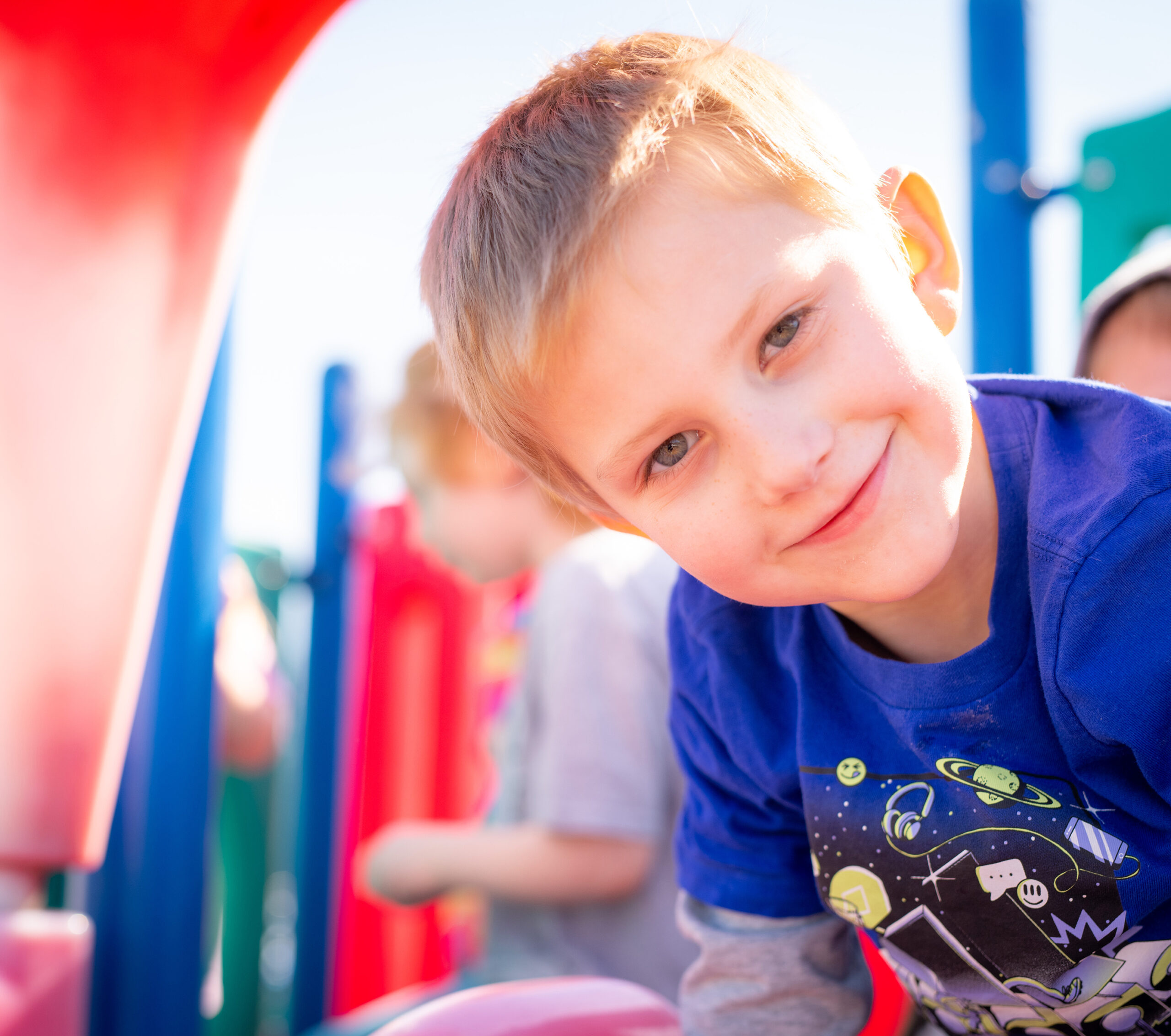 Photo of a smiling boy on a playground.
