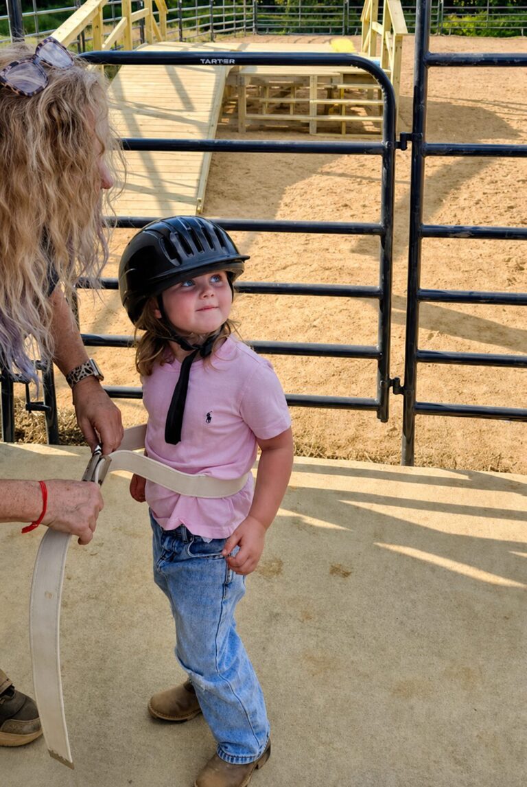 A child gearing up to ride a horse