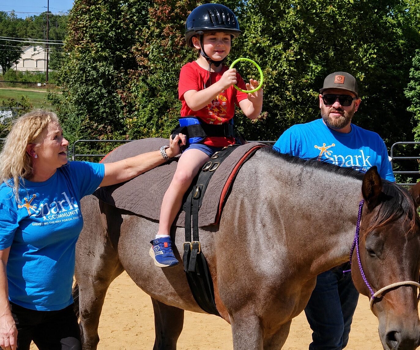 Child riding horse wile holding plastic rings